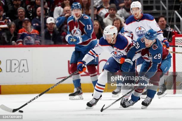 Connor McDavid of the Edmonton Oilers skates against Nathan MacKinnon of the Colorado Avalanche at Ball Arena on February 19, 2023 in Denver,...