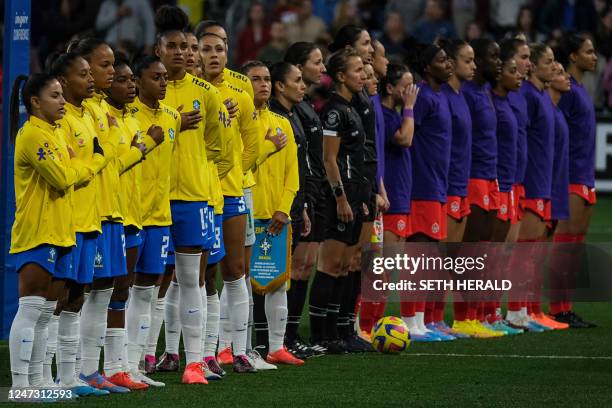 Members of the Brazilian and Canadian womens national soccer teams observe their respective national anthems before the start of the 2023 SheBelieves...