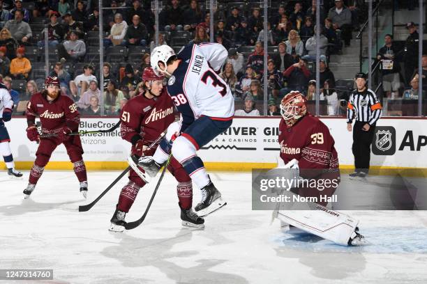 Connor Ingram of the Arizona Coyotes makes a save as Boone Jenner of the Columbus Blue Jackets jumps to avoid the puck during the second period at...