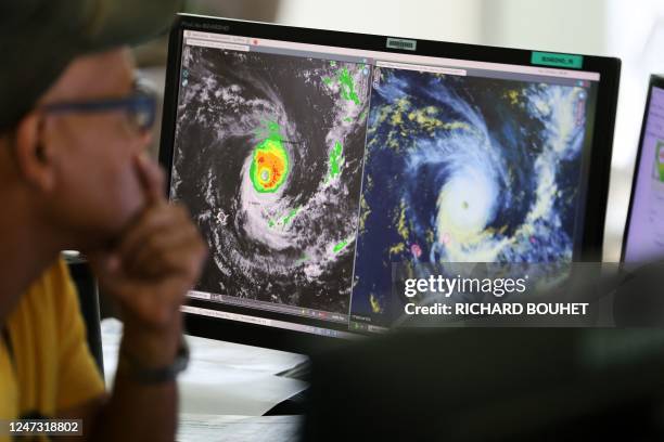 Forecasters watch satelitte control screens as they monitor Cyclone Freddy at the France weather station, Meteo France, in Saint Denis de la Reunion,...