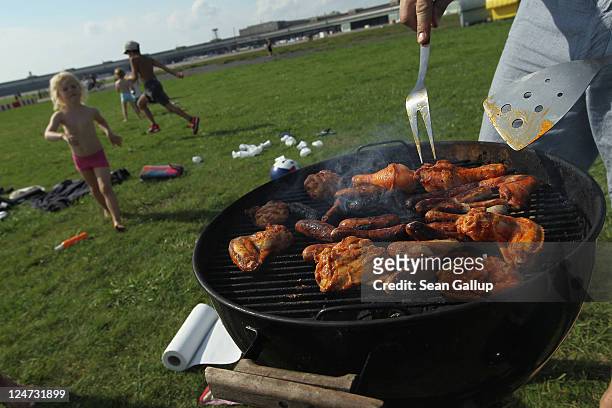 Family relax and prepare barbecued chicken and sausages at former Tempelhof airport on September 11, 2011 in Berlin, Germany. Tempelhof, located in...