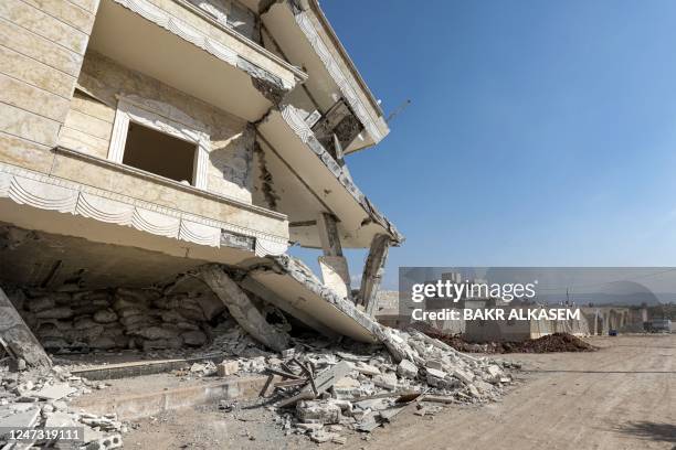 This picture taken on February 19, 2023 shows a view of a heavily-damaged building whose bottom section is used to store vegetables and foodstuffs,...