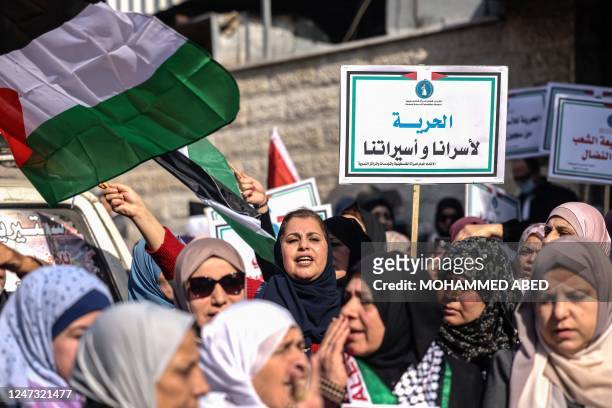 Women lift placards as they rally to express support for Palestinian prisoners in Israeli jails, outside the International Committee of the Red Cross...