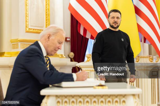 In this handout photo issued by the Ukrainian Presidential Press Office, U.S. President Joe Biden signs the guest book during a meeting with...
