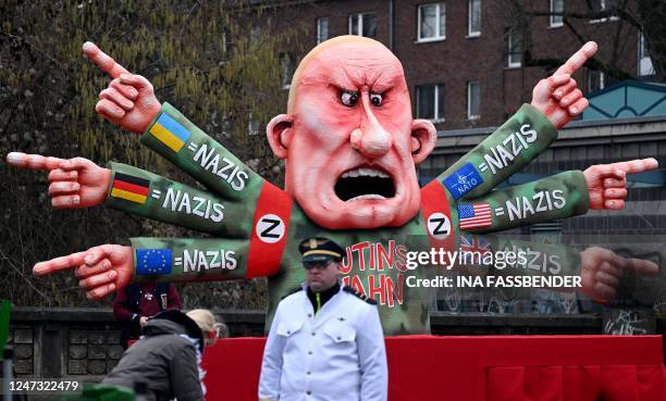 Man stands in front of a carnival float featuring Russian oligarch Yevgeny Viktorovich Prigozhin, co-founder of the Russian state-backed mercenary...