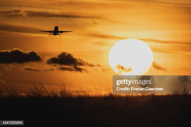 Starting airplane is pictured in as silhouette in front of the sunset near the BER airport on February 19, 2023 in Berlin, Germany.