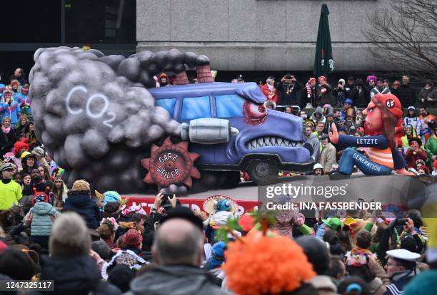 Carnival float featuring a climate activist of the "Last Generation" movement stopping CO2 emissions coming out of chimneys and the Garzweiler...