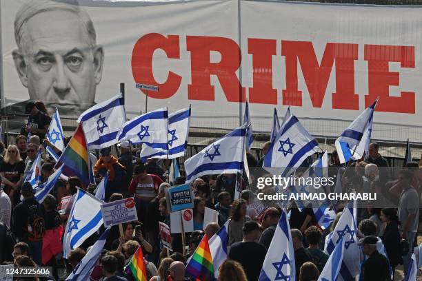 People gather with Israeli flags during a protest against the government's judicial reform bill near the Knesset in Jerusalem on February 20, 2023. -...