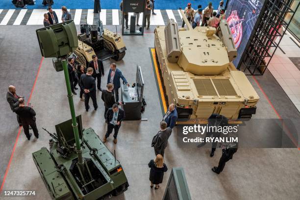 Visitors view the Type-X robotic combat vehicle at the EDGE pavilion during the International Defence Exhibtion at the Abu Dhabi International...