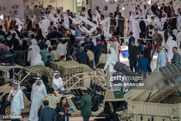 Visitors tour in a showroom by all-terrain vehicles produced by US company Flyer Defense during the International Defence Exhibtion at the Abu Dhabi...