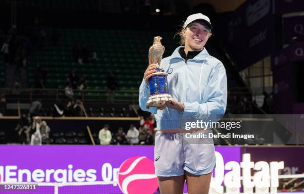 Iga Swiatek of Poland celebrates with the trophy on the podium after defeating Jessica Pegula of USA in the final match on day six of the Qatar Total...