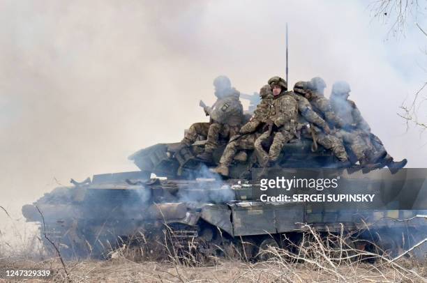 Ukrainian soldiers sit atop main battle tanks deploying smokescreens as they take part in military drills as they work out a possible attack in...