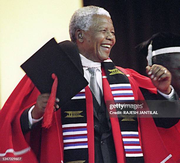 Former South African President Nelson Mandela waves to students and dances 23 September 1999, at the University of Durban-Westville after receiving...