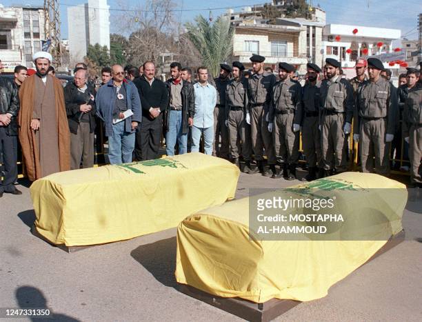 Hezbollah Sheikh Nabil Kaouk stands next to representative of the International Committee of the Red Cross while Hezbollah militants stand guard next...