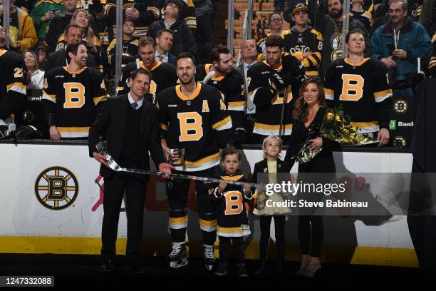 Celebrating his 1000th NHL game General Manager Don Sweeney presents a Traditional Silver Stick to David Krejci of the Boston Bruins in a ceremony...