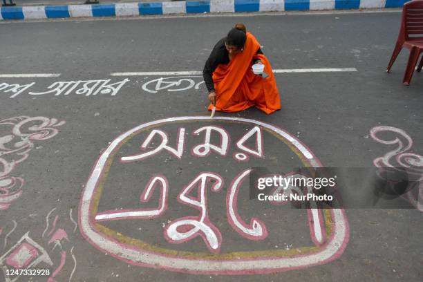 People are seen writing various messages on road in Bengali to commemorate International mother language day in Kolkata , India , on 20 February 2023...