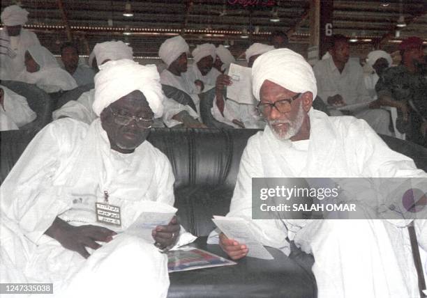 Sudan's former parliament speaker Hassan al-Turabi talks to his aide Ali al-Haj Mohammad during a meeting of the ruling National Congress 23 January...