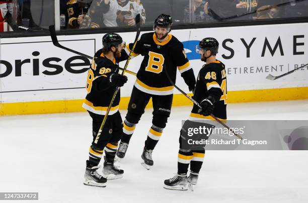 David Pastrnak of the Boston Bruins celebrates with his teammates Pavel Zacha and David Krejci after he scored his second goal of the game against...