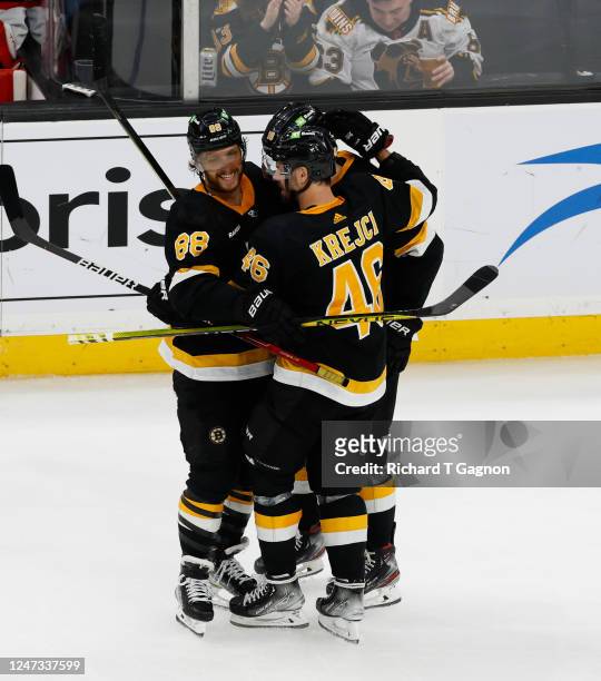 David Pastrnak of the Boston Bruins celebrates with his teammates Pavel Zacha and David Krejci after he scored his second goal of the game against...