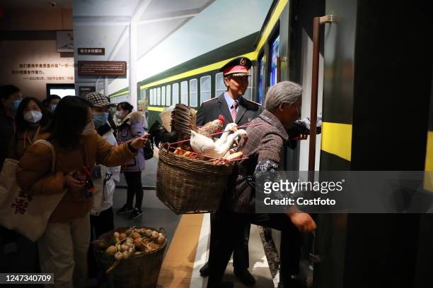 An elderly woman carrying a pail of ducks boards a train in Xi 'an, Shaanxi province, China, February 18, 2023. A customized cultural train with a...