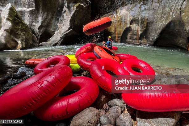 Tourist guides prepare inflatables to cross the Guape canyon in La Uribe municipality in the Meta Department, Colombia, on February 19, 2022. - The...