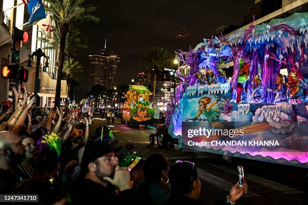 Revellers catch beads from a float in the 2023 Krewe of Proteus parade during Mardi Gras in New Orleans, Louisiana, on February 20, 2023.