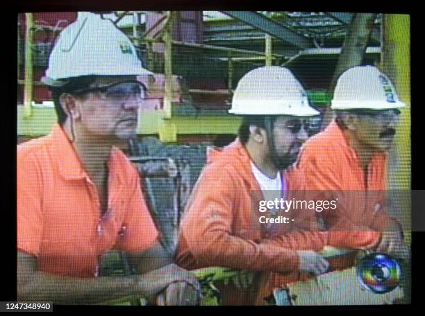 Employees of Brazilian company Petrobras observe the P-36 oil rig sink 20 March 2001 from another rig, 150 km off the Macae shore, Rio de Janeiro,...