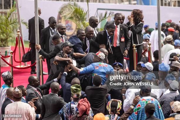 Security fight off members of the All Progressives Congress as they try to access the red carpet at the Teslim Balogun Stadium during their final...