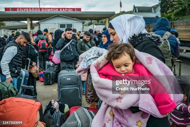 Syrian woman holds her baby in a queue in Cilvegozu, a turkish border with Syria. Many syrians are returning to home after the violent earthquake in...