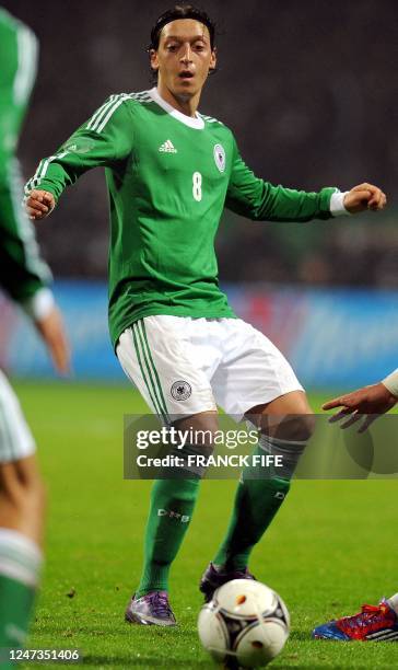 Germany's midfielder Mesut Ozil passes the ball during the friendly football match Germany vs France on February 29 at the Weser Stadium in Breme,...