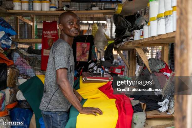 February 2023, Ghana, Accra: A man works at a market at a train station in Accra where, among other things, clothes from Europe are sold or processed...