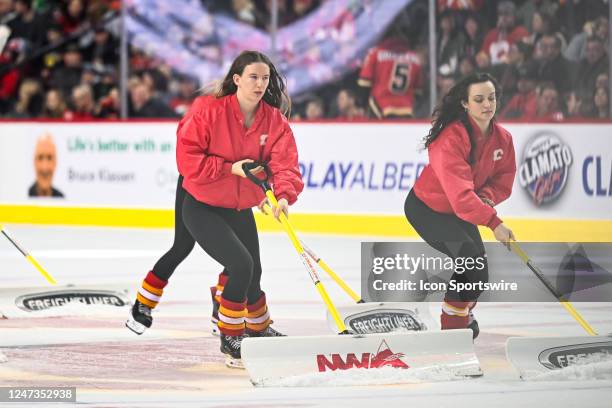 Calgary Flames ice girls clean the ice during the second period of an NHL game between the Calgary Flames and the Philadelphia Flyers on February 20...