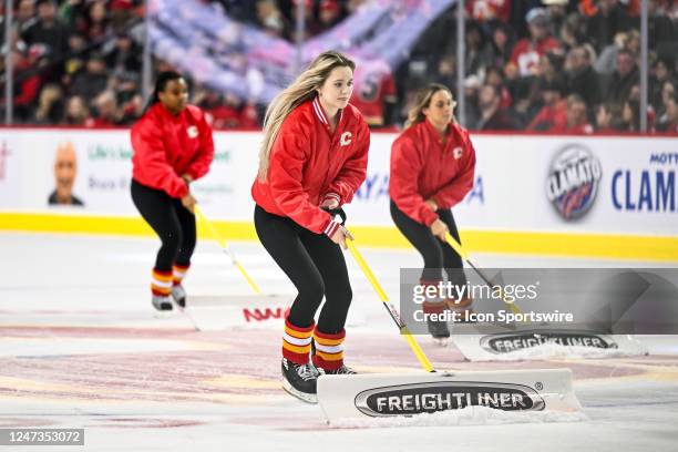 Calgary Flames ice girls clean the ice during the second period of an NHL game between the Calgary Flames and the Philadelphia Flyers on February 20...