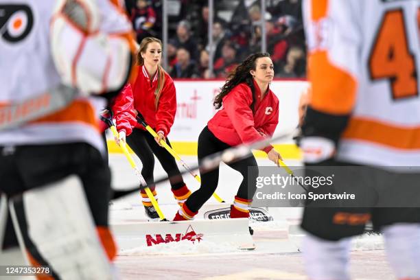 Calgary Flames ice girls clean the ice during the second period of an NHL game between the Calgary Flames and the Philadelphia Flyers on February 20...