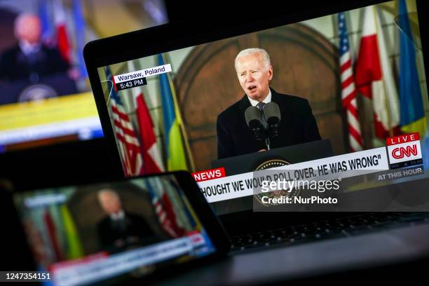 Live streaming of US President Joe Biden, giving a speech at the Royal Warsaw Castle Gardens in Poland, is displayed on multiple screens for...