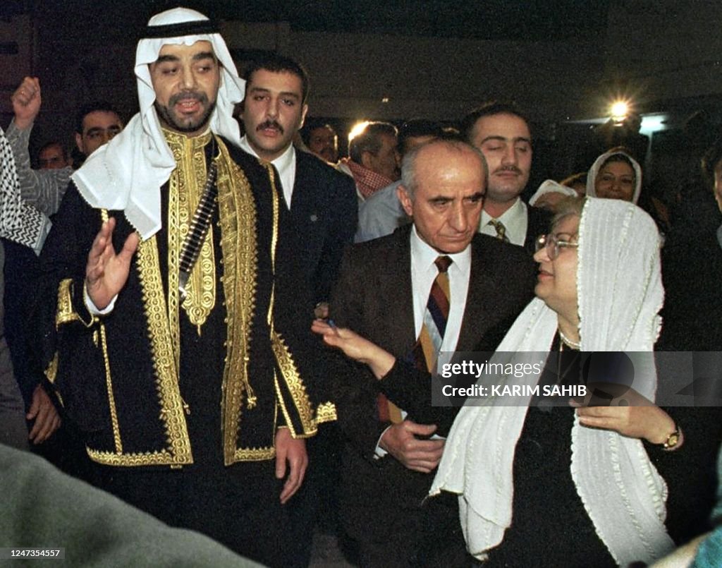 Uday Reebye An Iraqi woman walks alongside Uday Saddam Hussein, son of the Iraqi ...