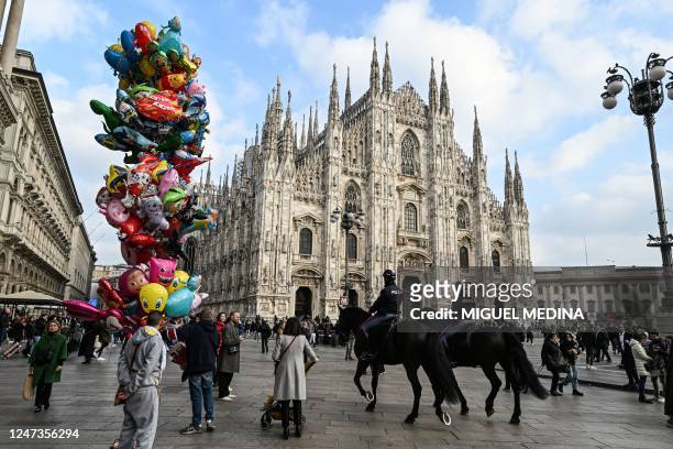 Italian police officers riding horses patrol in front of the Duomo di Milano on Duomo square, in central Milan, on February 21, 2023.