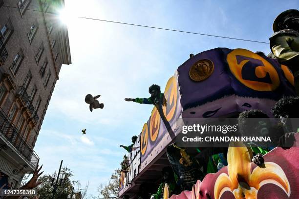 Revellers catch objects from a float in the 2023 Zulu Social Aid and Pleasure Club parade during a Mardi Gras celebration in New Orleans, Louisiana,...