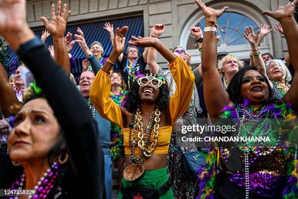 Revellers catch beads from a float in the 2023 Zulu Social Aid and Pleasure Club parade during a Mardi Gras celebration in New Orleans, Louisiana,...