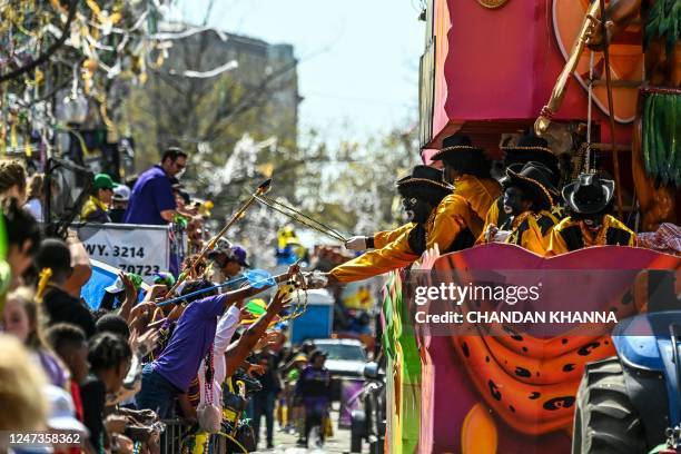 Revellers catch beads from a float in the 2023 Zulu Social Aid and Pleasure Club parade during a Mardi Gras celebration in New Orleans, Louisiana,...