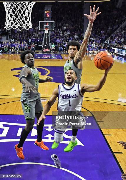 Markquis Nowell of the Kansas State Wildcats loses his shoe as he drives to the basket against Jalen Bridges and Jonathan Tchamwa Tchatchoua of the...