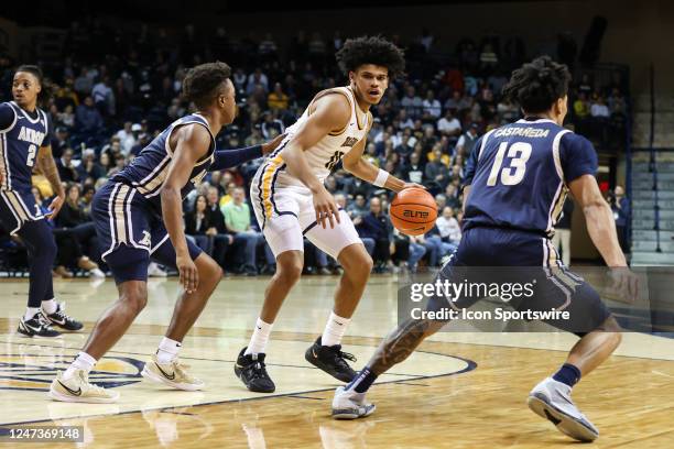 Toledo Rockets guard RayJ Dennis dribbles the ball while being defended by Akron Zips guard Tavari Johnson , left, and Akron Zips guard Xavier...