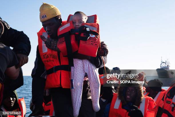 Man holds a seven-month-old baby girl in his arms to hand her to the NGO Aita Mari sea rescue team. At around 7:30 a.m. On Tuesday, 21 February, 40...