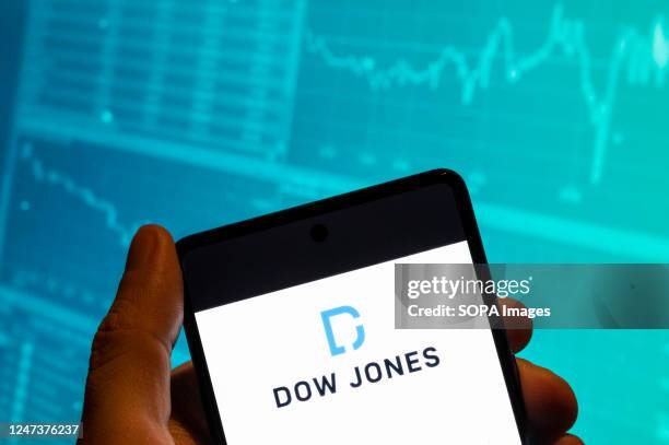 In this photo illustration, the American stock market index of the 30 prominent companies Dow Jones Industrial Average logo is seen displayed on a...