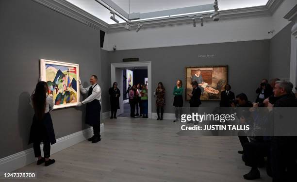 Employees poses with an artwork entitled 'Murnau mit Kirche II' by Wassily Kandinsky, during a photocall at Sotheby's auction house in central London...