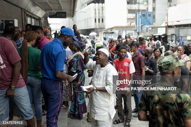 People queue outside a bank in Lagos on February 22, 2023 ahead of the Nigerian presidential election scheduled for February 25, 2023. - Nigeria has...