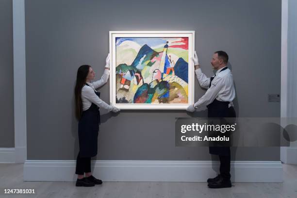 Art handlers hold a painting by Wassily Kandinsky, Murnau mit Kirche II , 1910 during a photo call for the upcoming Modern and Contemporary Evening...