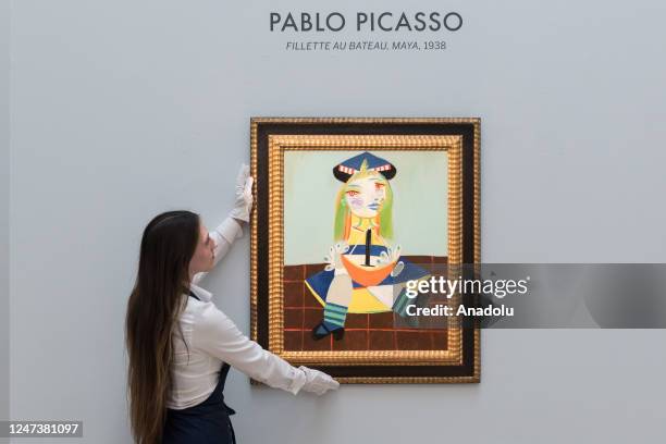 An art handler holds a painting by Pablo Picasso, Fillette au bateau during a photo call for the upcoming Modern and Contemporary Evening Auction at...