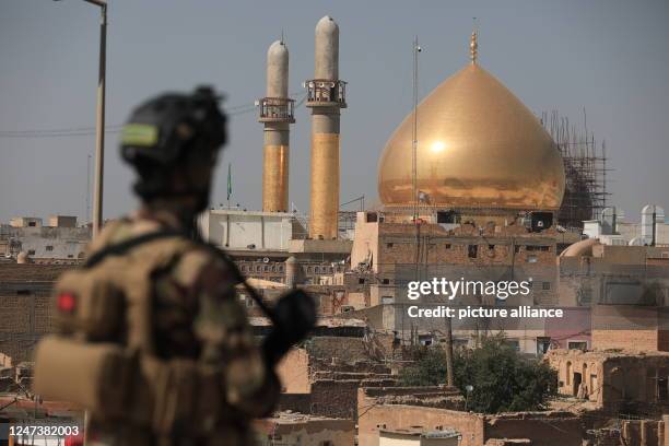 February 2023, Iraq, Samarra: A soldier stands in front of Al-Askari mosque, Resting Place of the Two Imams Ali al-Hadi and Hassan the al-Askari,...