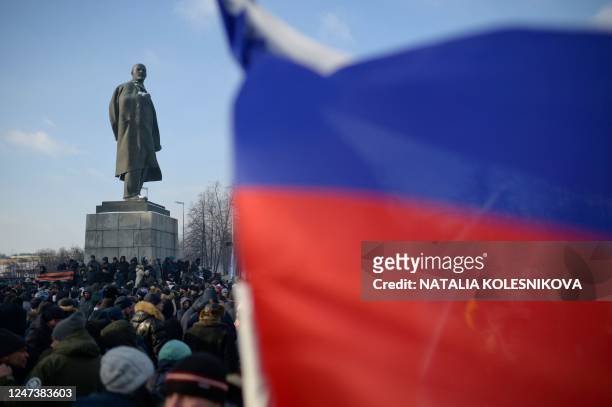 People gather near a monument to the founder of the Soviet Union Vladimir Lenin as they arrive for a patriotic concert dedicated to the upcoming...